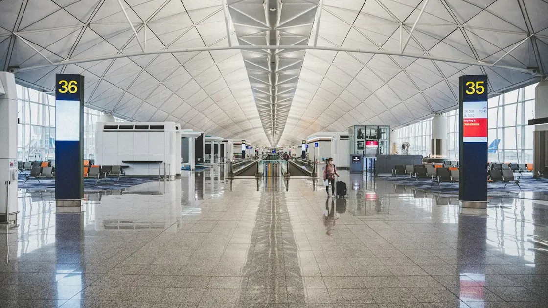 A traveller with a suitcase walking through an airport terminal